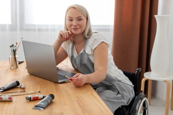 A disabled young woman is sitting at a desk A disabled young woman is sitting at a desk