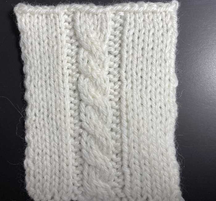 Knit a Cable:  Single Cross Single cross cable swatch worked in white wool yarn