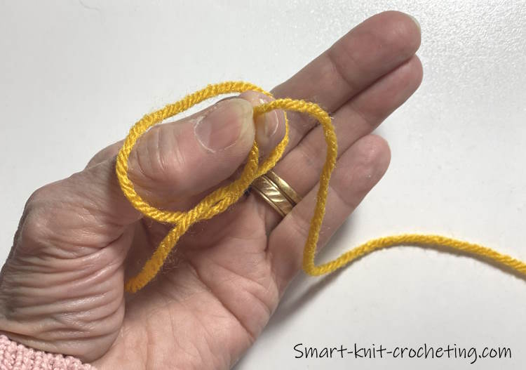 Using two fingers to pinch the center of the loop, the slip knot is created