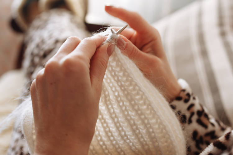 A person is knitting in the foreground