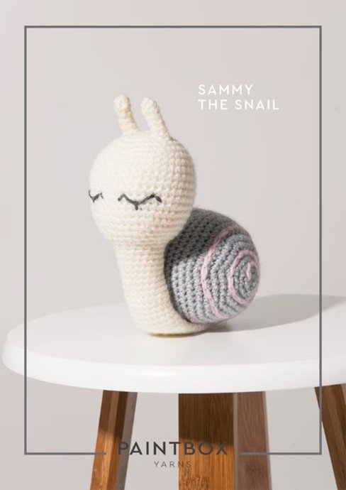 A snail toy crocheted in white yarn