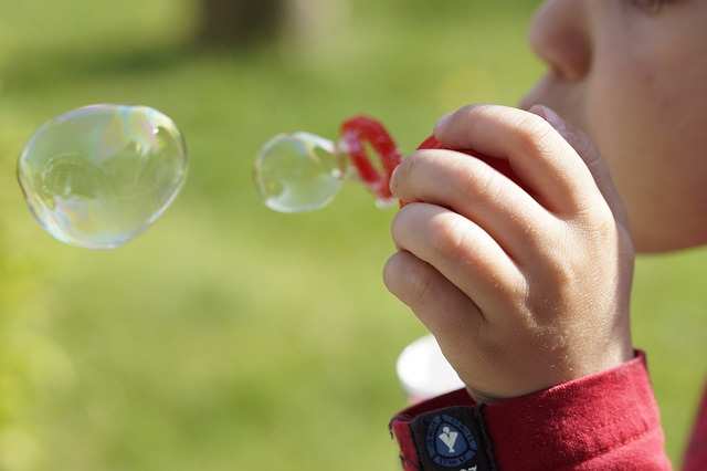 A young boy is blowing bubbles