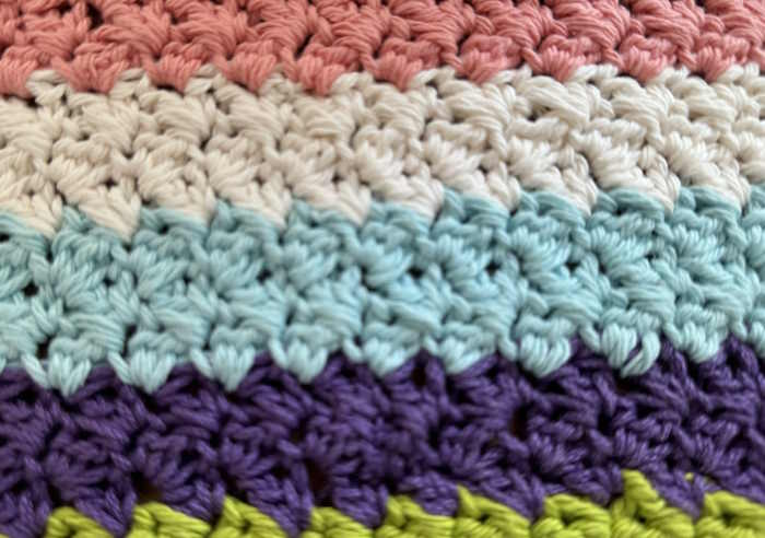 The crochet suzette stitch worked in different colors shown as a close up image. The crochet suzette stitch worked in different colors shown as a close up image.