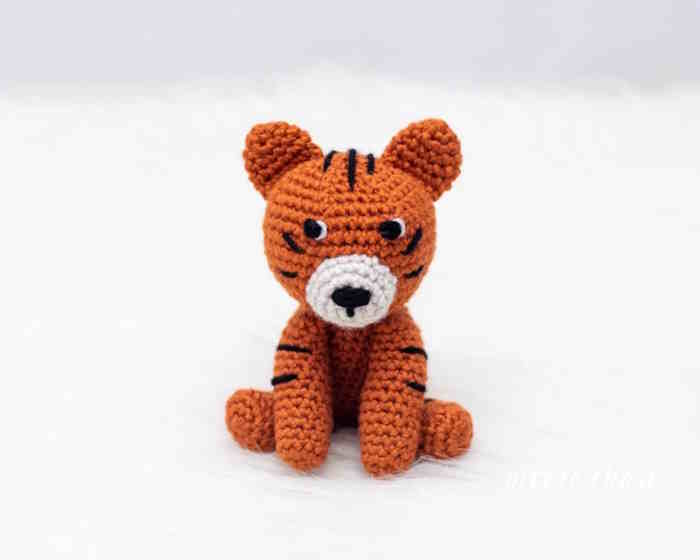 A small toy tiger crocheted in orange and black yarn