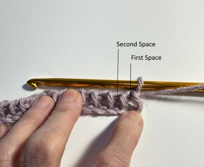 Tunisian full stitch with arrows pointing to the first and second space