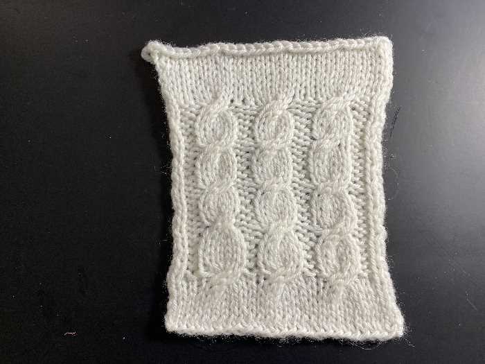 Knit a Cable:  Uneven Rope Cable Uneven rope cable worked in white yarn.