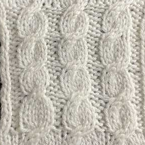 A knitted swatch showing the rope cable pattern, worked in white yarn.