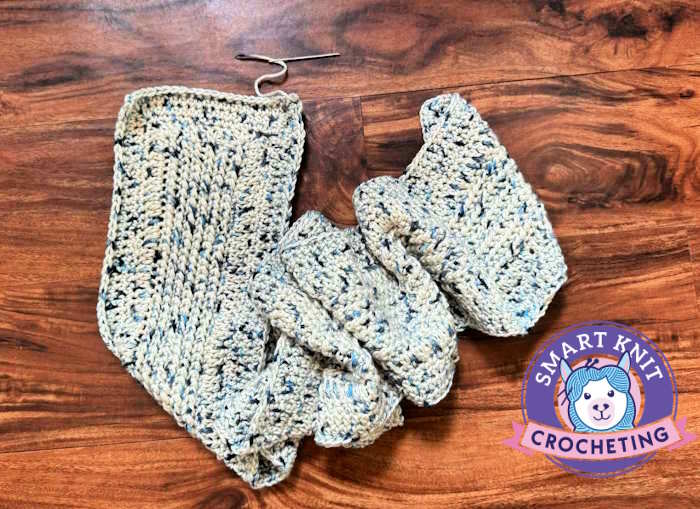 A crochet scarf is shown finished except of weaving in ends.