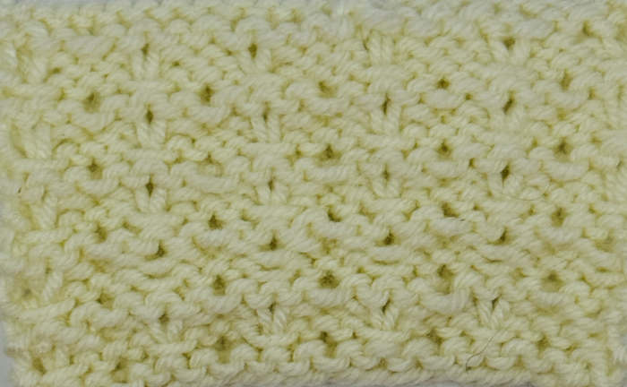 Wrong side showing of the knit whelk stitch worked in a cream color.