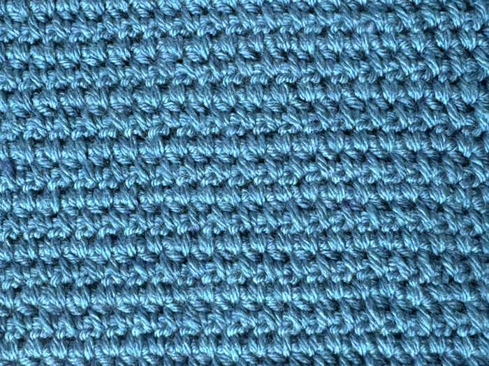 A swatch of wide half double crochet worked in blue yarn