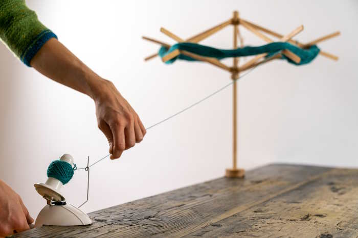 Yarn Swift and Ball Winder A woman is working with a yarn swift and ball winder