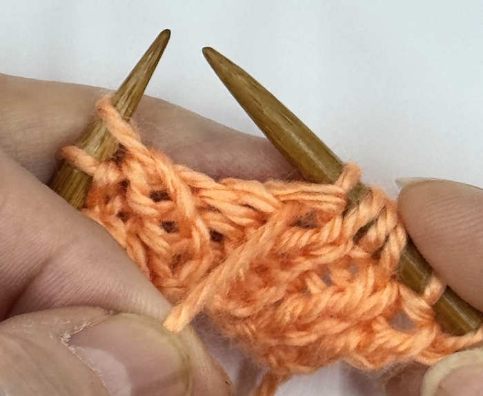 A yarnover between a purl and a knit stitch