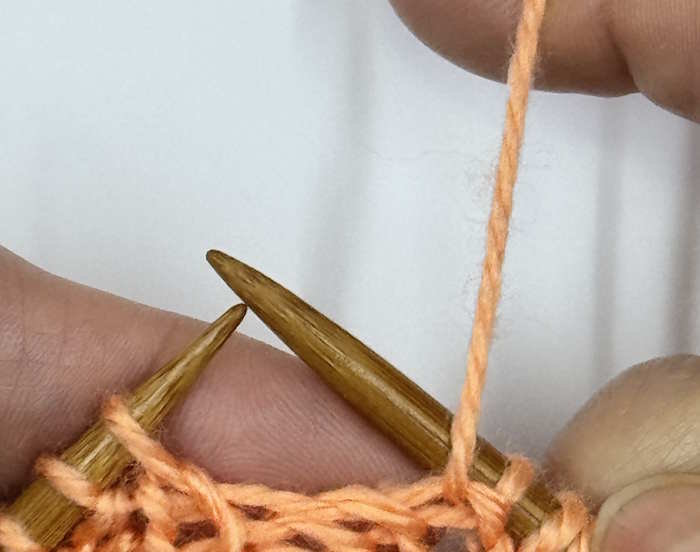 A yarnover made between a purl and knit stitch, step 2